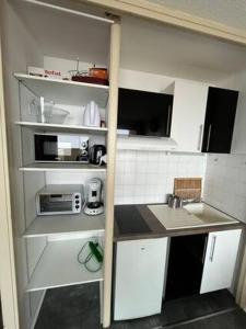 サン・ラリー・スランにあるAppartement Pied des pistes Vue sur les sommetsの小さなキッチン(白いキャビネット、電子レンジ付) +8枚の写真