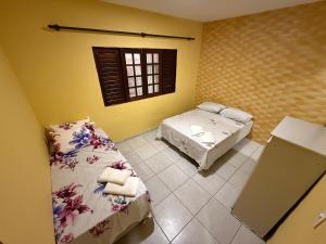 una camera da letto con due letti e una finestra di Refúgio Paripueira a Paripueira Altre 26 foto