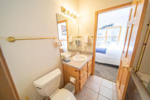 a bathroom with a toilet and a sink and a mirror at Snake River 44 by SummitCove Lodging in Keystone +33 photos