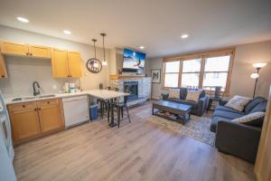 eine Küche und ein Wohnzimmer mit Sofa und Tisch in der Unterkunft Silver Mill 8211 by SummitCove Lodging in Keystone