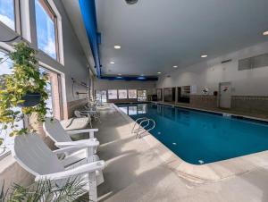 une piscine avec deux chaises blanches et une piscine dans l'établissement Decatur 1804 by SummitCove Lodging, à Keystone