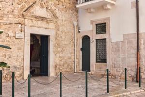 a building with a black door and a fence at Dimora Storica a Trani con Terrazzo Jacuzzi x Dimora Storica a Trani con Terrazzo e Jacuzzi con 6 Posti Letto e Aria Condizionata in Trani