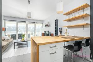 a kitchen with a counter and a living room at Your Holidays Playa Baltis in Międzyzdroje