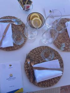 a table with two baskets and glasses and plates and napkins at Hotel Albatros in Ischia