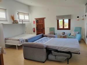 a bedroom with a bed and a couch and chairs at Finca Santa Lucía Alojamientos in Mazarambroz
