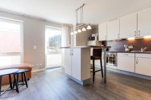 a kitchen with white cabinets and a table and chairs at Fehmarnstrand 78 App 9 in Staberdorf