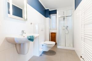 a white bathroom with a sink and a toilet at Fehmarnstrand 78 App 9 in Staberdorf +8 photos
