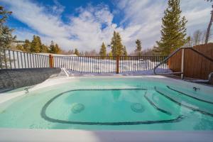 un jacuzzi dans une cour arrière avec une clôture dans l'établissement Antlers Gulch 502 by SummitCove Lodging, à Keystone