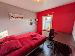 a red bedroom with a red bed and a desk at Derrière l'étang- maison moderne in Pordic