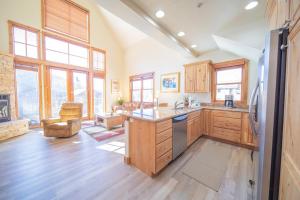 a large kitchen with wooden floors and windows at Antlers Gulch 502 by SummitCove Lodging in Keystone