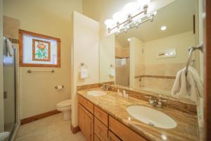 a bathroom with two sinks and a large mirror at Antlers Gulch 502 by SummitCove Lodging in Keystone +43 photos