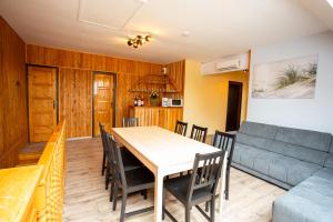a dining room with a table and a couch at Strandi Apartmanok- Levente in Balatonmáriafürdő