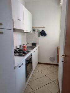a kitchen with white cabinets and a stove top oven at Studio with terrace in Busto Arsizio