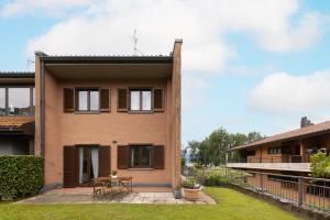 a house with a courtyard in front of it at Damler Suite FronteLago in Maccagno con Pino e Veddasca
