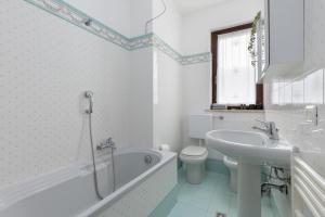 a bathroom with a tub and a toilet and a sink at Damler Suite FronteLago in Maccagno con Pino e Veddasca +22 photos