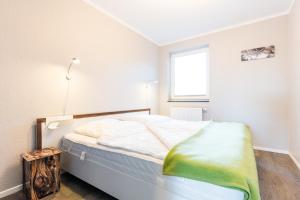 a bedroom with a bed and a window at Fehmarnstrand 78 App 12 in Staberdorf