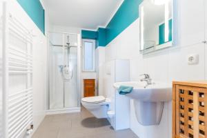 a bathroom with a toilet and a sink and a shower at Fehmarnstrand 78 App 10 in Staberdorf