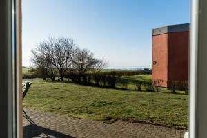 an open door to a field with a building at Fehmarnstrand 78 App 10 in Staberdorf