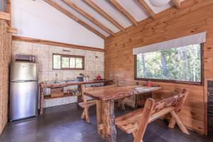a kitchen with a wooden table and a refrigerator at Cabaña en Pucon in Pucón