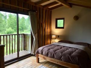 a bedroom with a bed and a large window at Cabaña en Pucon in Pucón