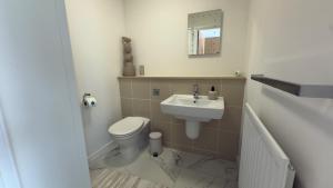 a bathroom with a toilet and a sink at Central M K 2-Bedroom Apartment Sleeps 4 Parking in Milton Keynes