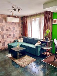 ソフィアにあるThe Green Apartment 2BR - free parkingの青いソファと緑の壁が備わるリビングルーム