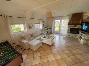 a living room with a couch and a pool table at Freistehendes Ferienhaus am See Nähe Roermond in Heel
