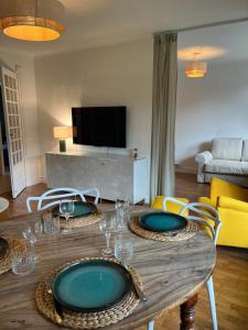 a wooden table with plates on it in a living room at New & Cozy in Lyon