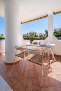 トロクスにあるGran Apartamento Laguna Beachの眺めの良いバルコニーにテーブルと椅子が置かれている