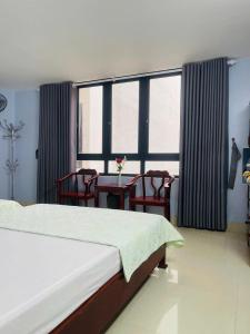 a bedroom with a bed and a table and chairs at Nhà nghỉ Thường Nga in Cat Ba +28 photos