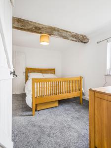 Un dormitorio con una cama de madera en una habitación. en 3 Bedroom Country Cottage with Private Garden, en Shifnal