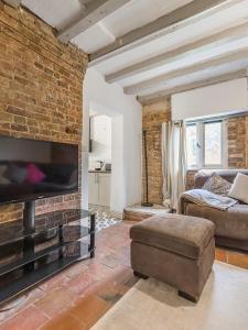 Una sala de estar con un sofá y una pared de ladrillos. en 3 Bedroom Country Cottage with Private Garden, en Shifnal