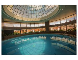 a large swimming pool in a building with a glass dome at ROLES Hotel in Sucre