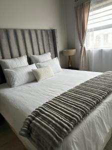Ένα ή περισσότερα κρεβάτια σε δωμάτιο στο Bytes Apartment - Midrand