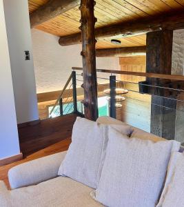 a living room with a couch and a wooden ceiling at Le Vénérable, 4 étoiles, vue imprenable au coeur des Vosges in Ventron