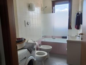 a bathroom with a toilet and a sink and a washing machine at Studio with terrace in Busto Arsizio