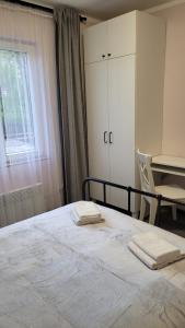 a bedroom with a bed with two towels on it at Vila KEDAR sa klimom in Kragujevac