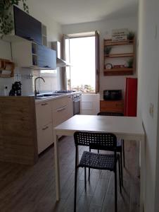 a kitchen with a white table and two chairs at Almarisa - appartamento vista mare in Salerno