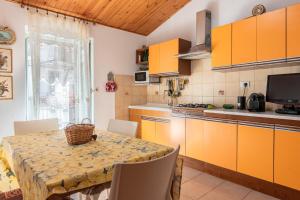 a kitchen with a table with chairs and orange cabinets at La Casetta Della Rocca Cefalù in Cefalù +12 photos