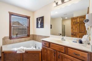 a bathroom with a tub and a sink at Cozy 'Rustic River Lodge' Near SDC with Pools! in Branson