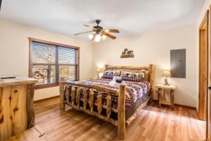 a bedroom with a bed and a ceiling fan at Cozy 'Rustic River Lodge' Near SDC with Pools! in Branson