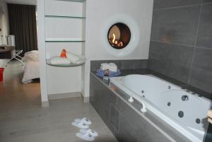 
a bath room with a tub and a toilet at Familiehotel Soll Cress Koksijde in Koksijde
