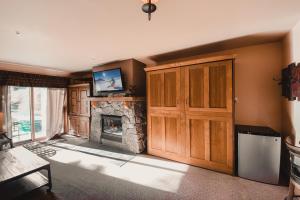 ein Wohnzimmer mit einem Kamin und einer Holztür in der Unterkunft Red Hawk Lodge 2222 by SummitCove Lodging in Keystone