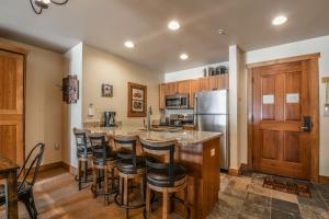 eine Küche mit einer Insel mit Barhockern in der Unterkunft Red Hawk Lodge 2222 by SummitCove Lodging in Keystone