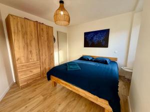 a bedroom with a blue bed and a wooden door at Coeur de ville in Saint-Brieuc
