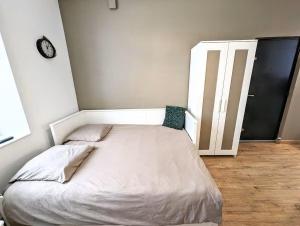 a bed in a room with a clock on the wall at Le Nid - studio cosy fraîchement rénové in Saint-Brieuc