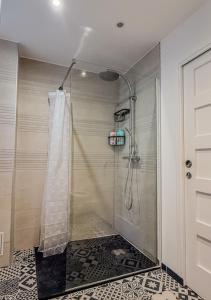 une douche avec une porte vitrée dans une salle de bain dans l'établissement Appart avec terrasse, vue & parking - hyper centre, à Chartres