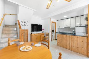 a kitchen and dining room with a wooden table in a room at Casa Calma in Santa Pola