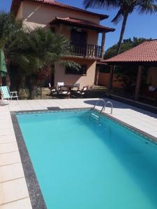 ein Swimmingpool vor einer Villa in der Unterkunft Casa Alto Padrão Casa Laranja in Praia Sêca