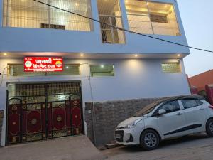 a small car parked in front of a building at Janki Paying Guest House in Ayodhya